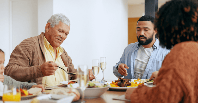 Family sitting around dinner table for a meal and conversation about assisted living.