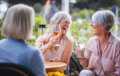 Senior women enjoying a glass of wine together and laughing