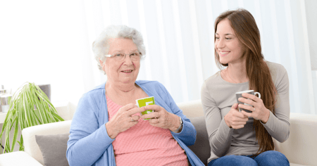 Senior woman in memory care on the sofa with adult daughter