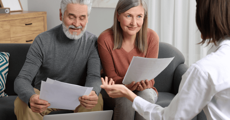 Elder couple sitting on the couch discussing benefits and features at an assisted living community