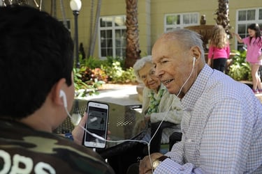 Engaging with a senior man by sharing headphones