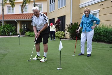  A senior couple playing golf in a senior living community