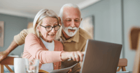 Man and woman couple pointing at computer screen.
