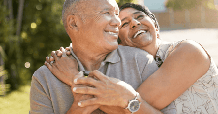 Senior couple with their arms wrapped around each other. 