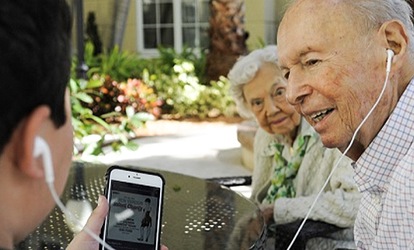 Grandparent listening to phone headphones. 