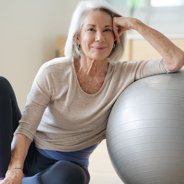 Woman leaning on exercise ball. 