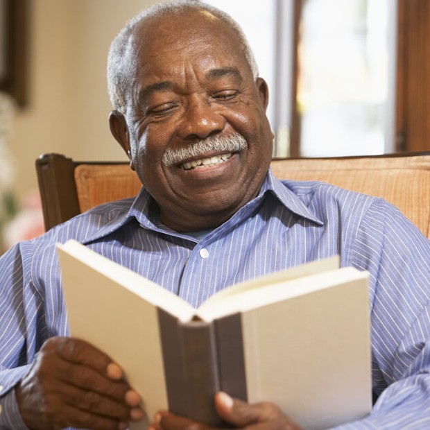 Man reading a book for book club. 