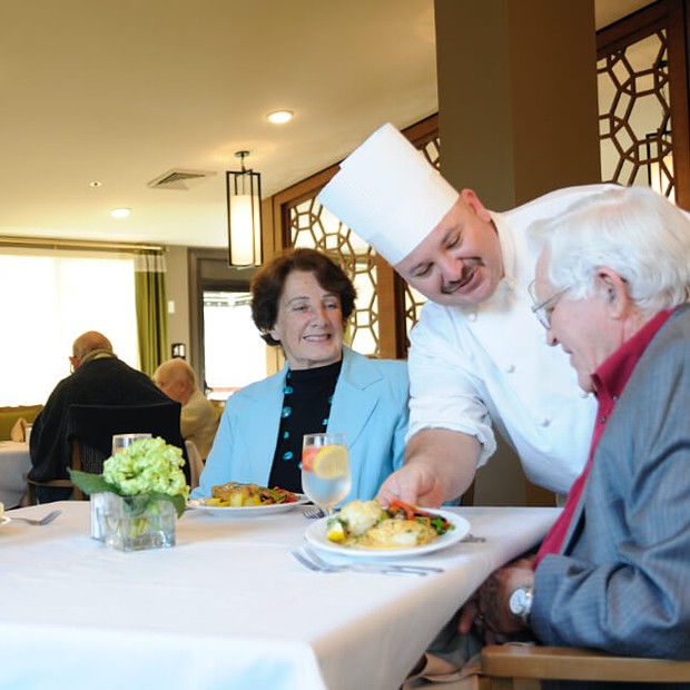 Chef serving lunch to couple. 