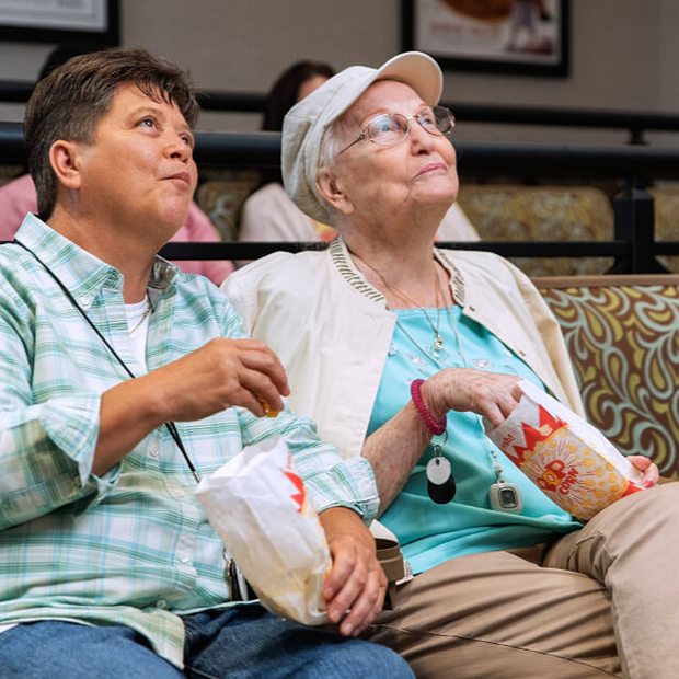 Residents enjoying a movie with popcorn. 