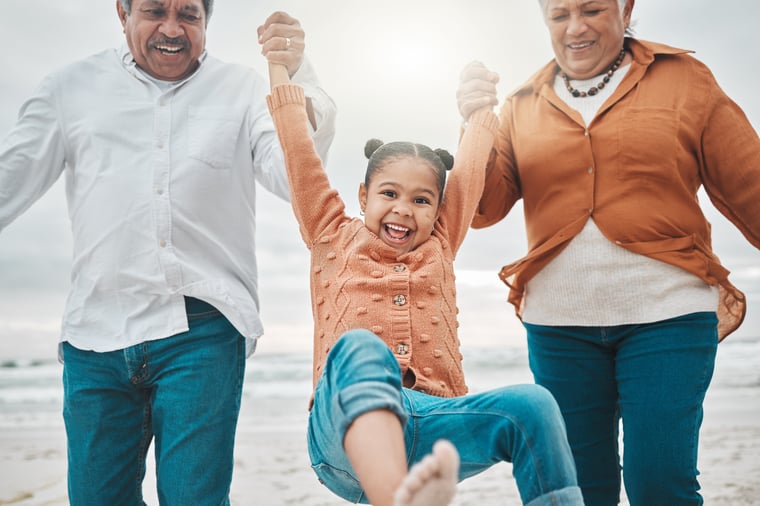 grandparents with grandchild on the beach