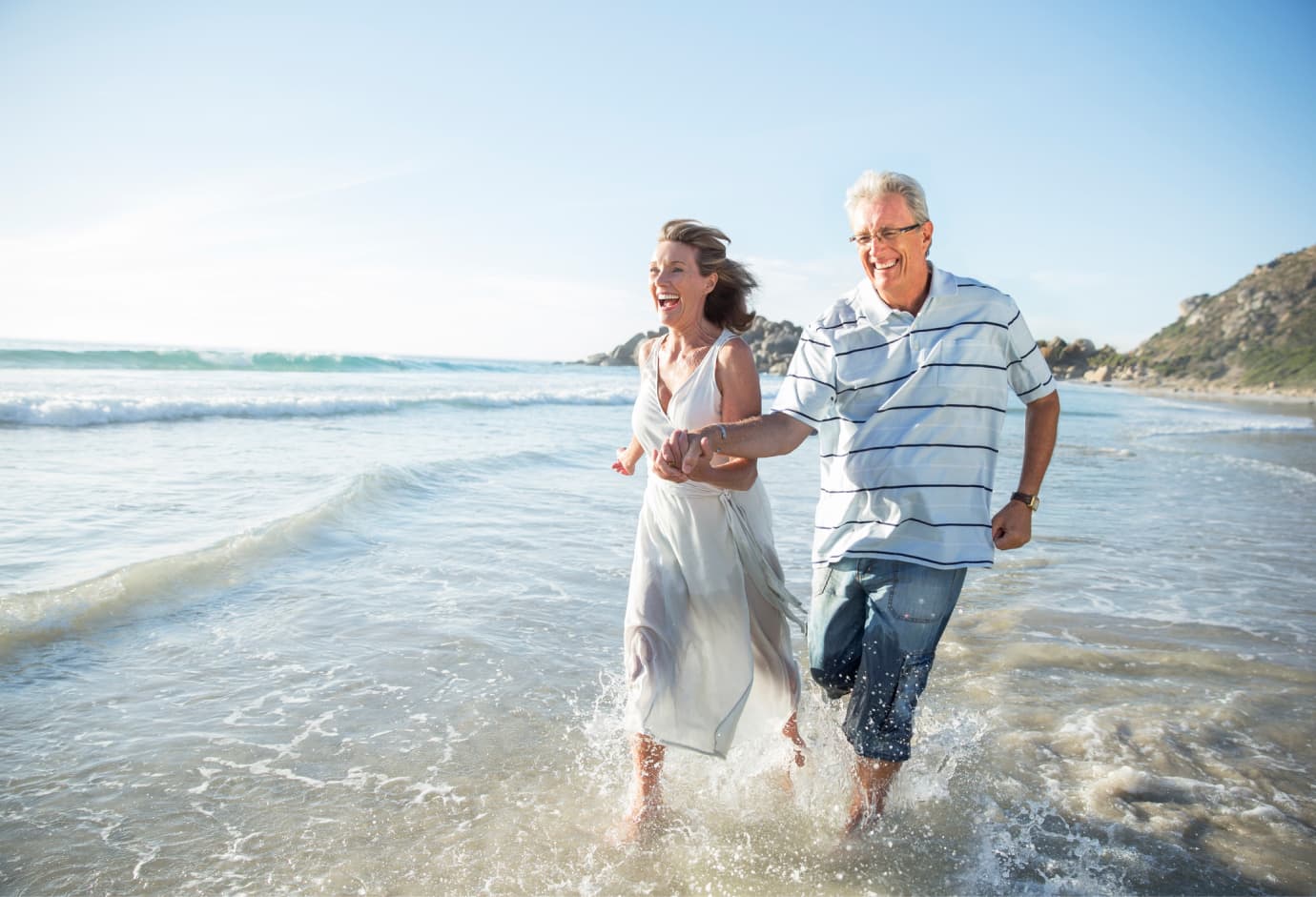 Couple running through ocean. 